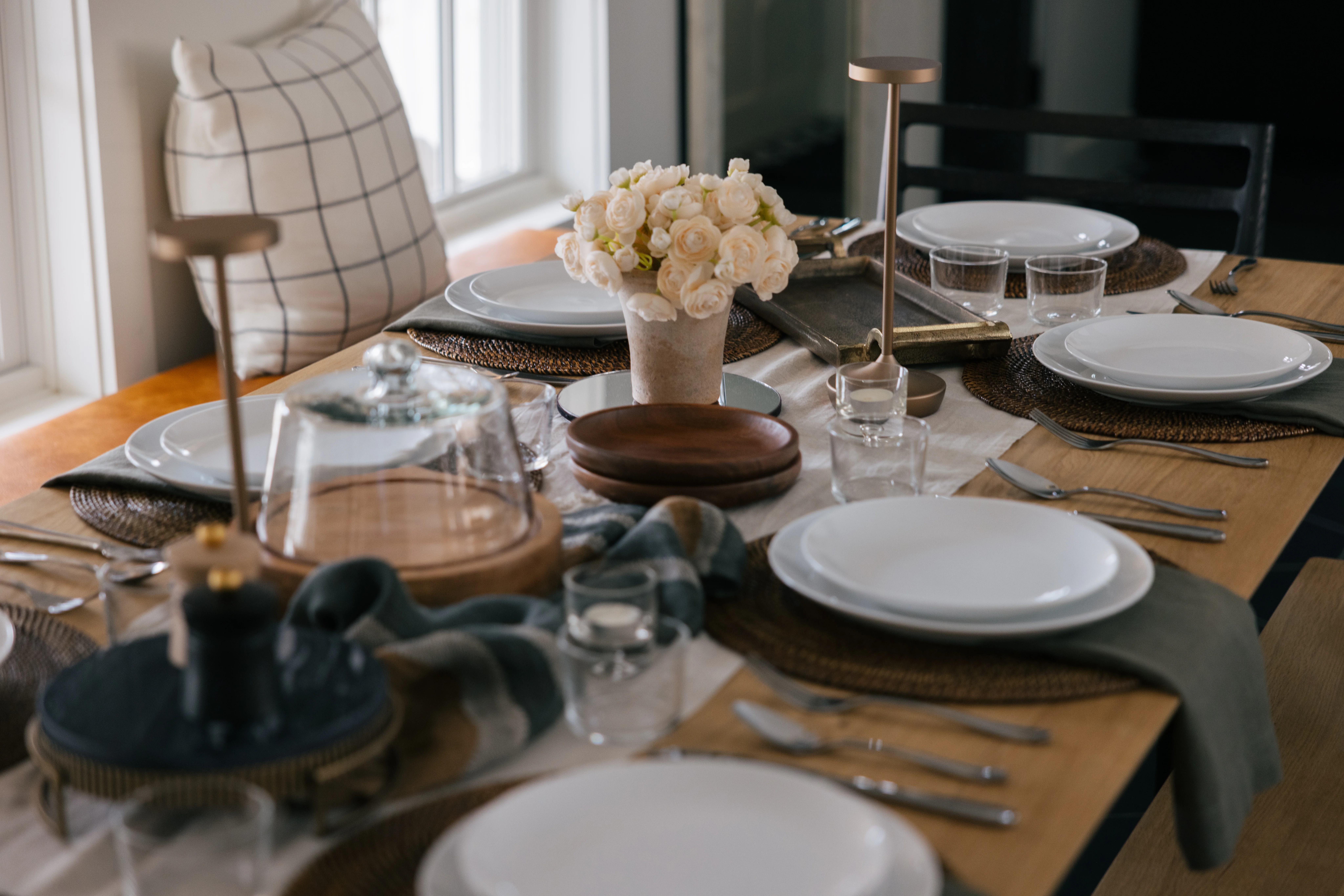 Dining table lifestyle shot with beautifully styled place settings and warm ambiance